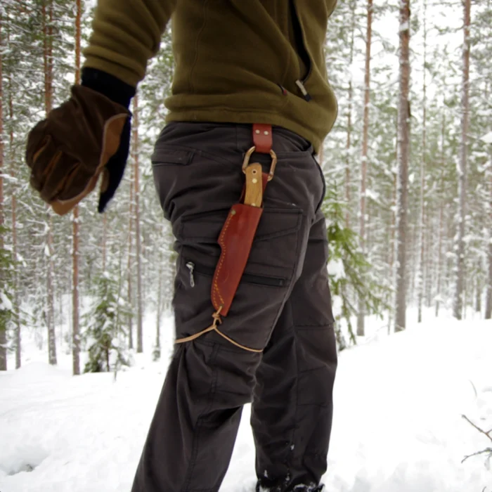 A Casström No.3 Dangler with a knife attached being used in the forest.